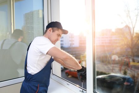 Construction worker repairing window in house