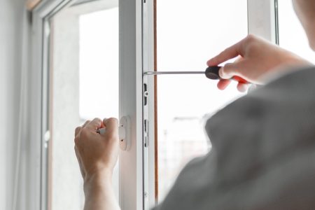 The worker installing and checking window in the house